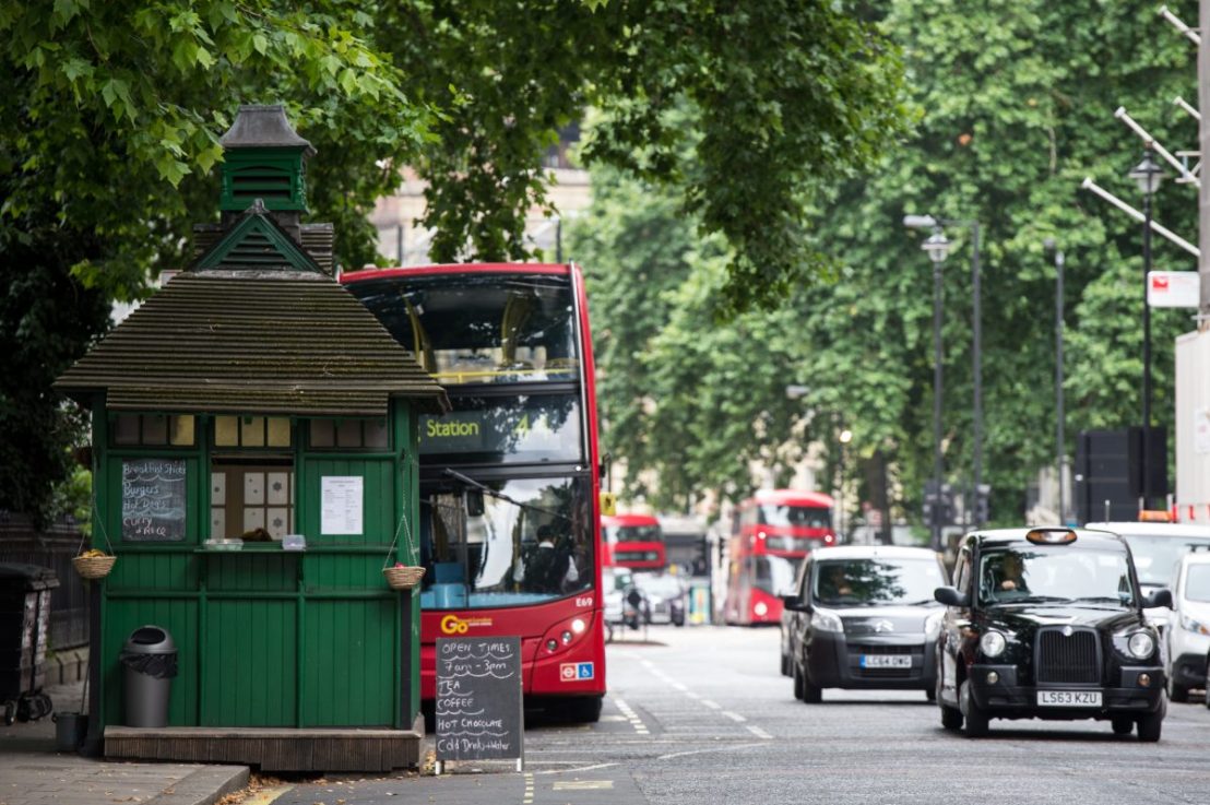 LONDON, ENGLAND - JULY 27:  A Hackney Carriage taxi drives past the Grosvenor Gardens Cabmen's Shelter on July 27, 2017 in London, England. The Cabmen's Shelters were established in 1875 when horse-drawn carriages called Hansom Cabs were used. Sixty-one were built across London up to 1914 to provide shelter, hot food and non-alcoholic drinks to the cab drivers. Now only 13 Cabmen's Shelters remain in London providing the same services to modern day Hackney Carriage cab drivers, commonly known as the black cab, as well as takeaway to the general public. All are now Grade II listed buildings, as they were in the 19th Century, and now are looked after by the charity Cabmen's Shelter Fund.  (Photo by Chris J Ratcliffe/Getty Images)