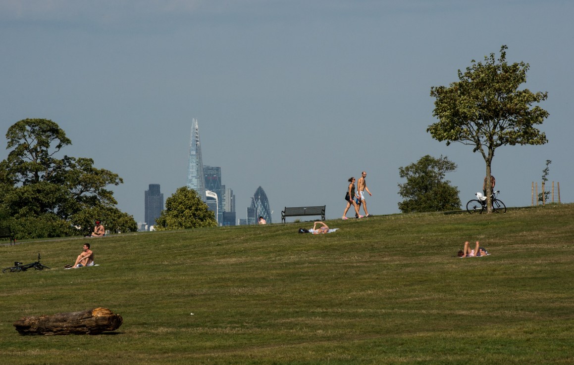 LONDON, ENGLAND - SEPTEMBER 13:  Sunbathers sit in Brockwell Park with a view of the Gherkin and Shard buildings in the distance on September 13, 2016  (Photo by Chris J Ratcliffe/Getty Images)