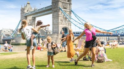 Londoners enjoying sunny spring weather in Potters Fields Park with blue skies and 16-degree temperatures