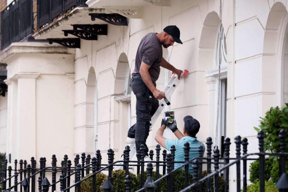 Two painters and decorators paint the underside of a balcony in Belgravia, on 21st May 2025 , in London, England. (Photo by Richard Baker / In Pictures via Getty Images)