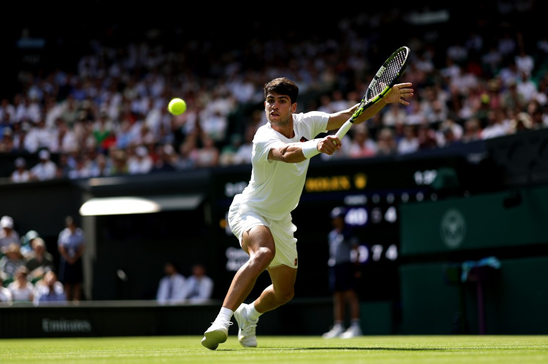 LONDON, ENGLAND - JUNE 30: Carlos Alcaraz of Spain plays a backhand against Fabio Fognini of Italy during the Gentlemen's Singles first round match on day one of The Championships Wimbledon 2025 at All England Lawn Tennis and Croquet Club on June 30, 2025 in London, England. (Photo by Julian Finney/Getty Images)