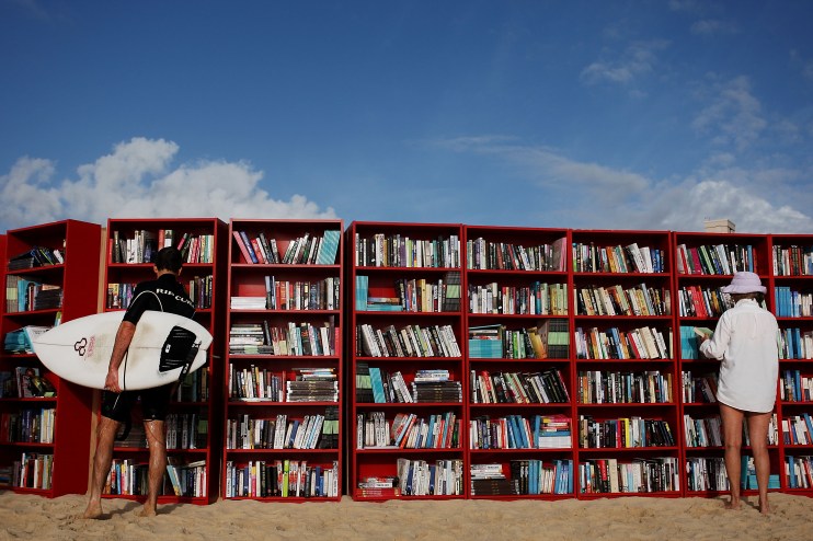 SYDNEY, AUSTRALIA - JANUARY 31: Beach goers select books from 30 red Ikea Billy bookcases lined up to form the world's longest outdoor bookcase to celebrate the 30th birthday of the brand's signature furniture piece, at Bondi Beach on January 31, 2010 in Sydney, Australia. The bookcases were filled with thousands of books which beachgoers can swap for one of their own or make a gold coin donation to buy, with proceeds to The Australian Literacy & Numeracy Foundation. (Photo by Lisa Maree Williams/Getty Images)
