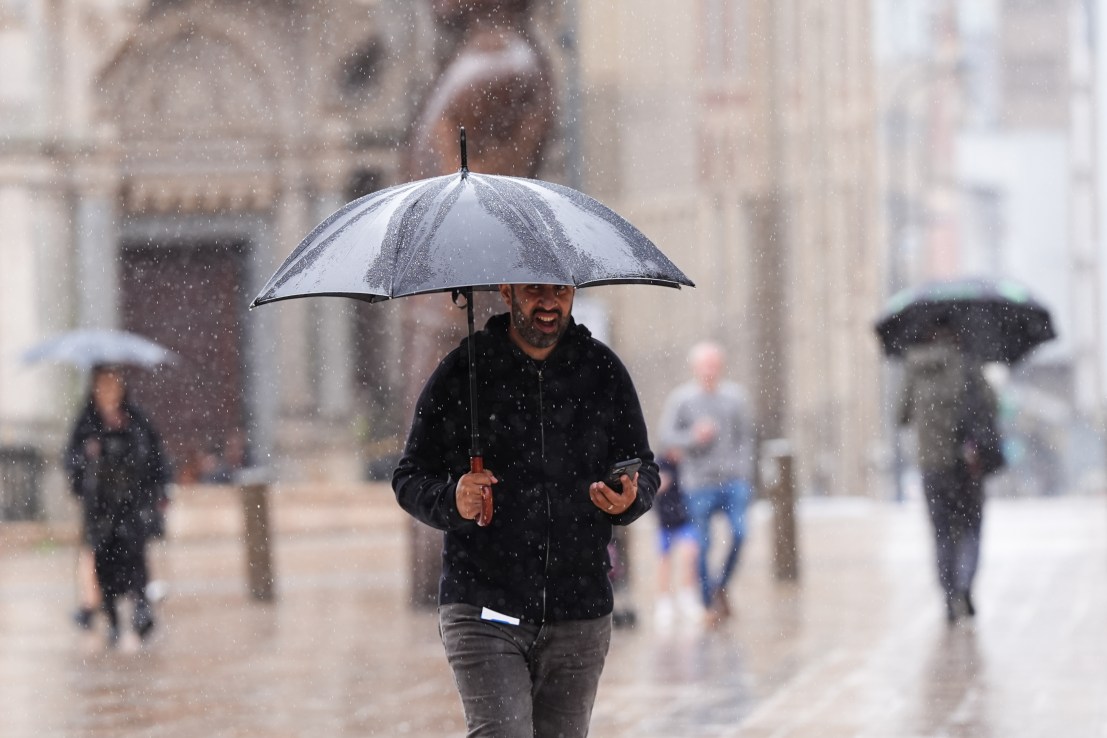 People use umbrellas during rainfall as they walk by Victoria Square in Birmingham. Monday August 4, 2025. PA Photo: Jacob King/PA Wire