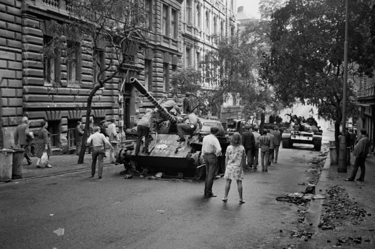 People stand on an abandoned tank in a street while pedestrians walk by during the Czech Crisis, Prague, Czechoslovakia, August 29th 1968. (Photo by Reg Lancaster/Daily Express/Hulton Archive/Getty Images)