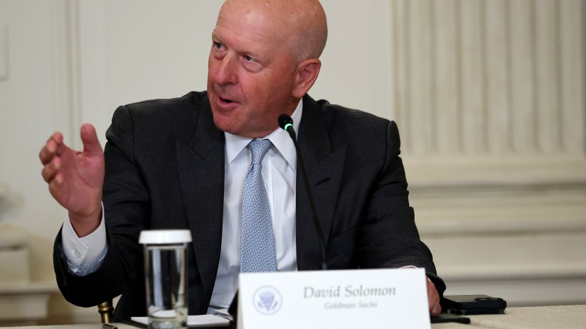 David Solomon speaking at a business conference, dressed in a suit, addressing a professional audience with a focused expr...