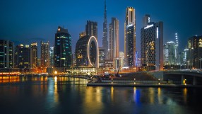 GettyImages 1431041604 showing business professionals discussing market trends in a conference room with charts in the bac...