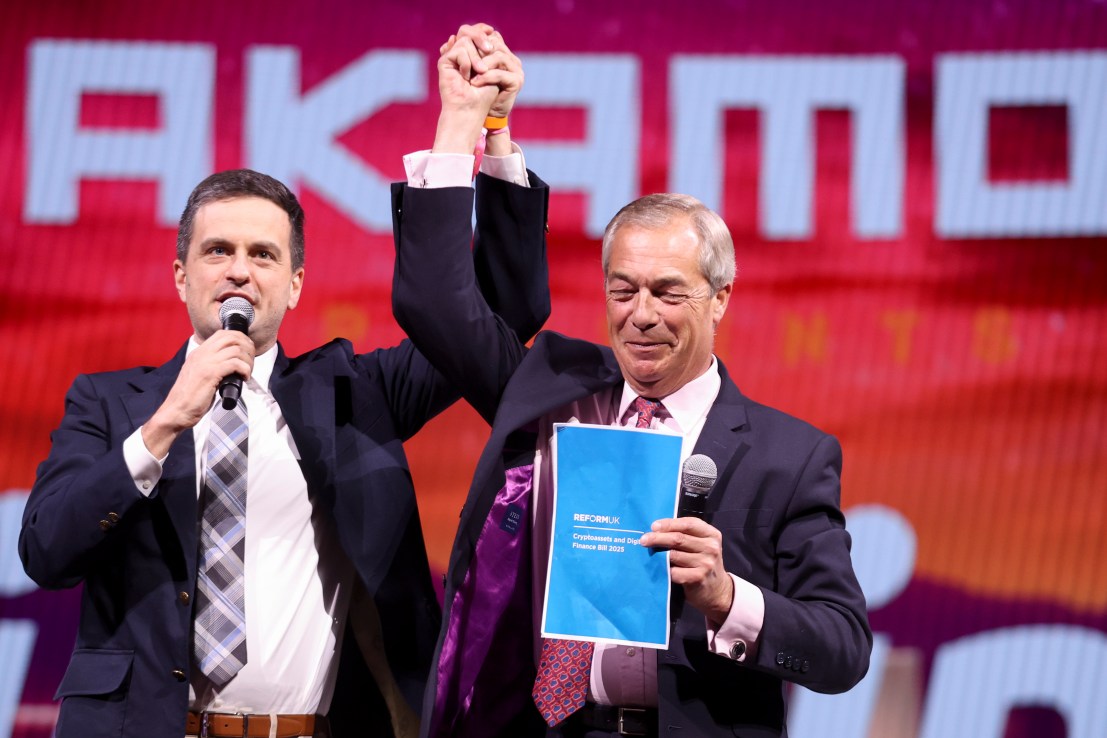 LAS VEGAS, NEVADA - MAY 29: Bitcoin Magazine's Frank Corva and UK Leader of the Reform Party Nigel Farage hold hands as Farage holds up a copy of his proposed Cryptocurrencies and Digital Finance Bill after their talk at The Bitcoin Conference at The Venetian Convention & Expo Center on May 29, 2025 in Las Vegas, Nevada. Farage spoke about the Reform Party's support of bitcoin and cryptocurrencies in the United Kingdom. (Photo by Ian Maule/Getty Images)