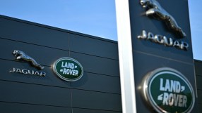 Breaking news scene with reporters gathering outside a corporate office building, covering a developing business story.