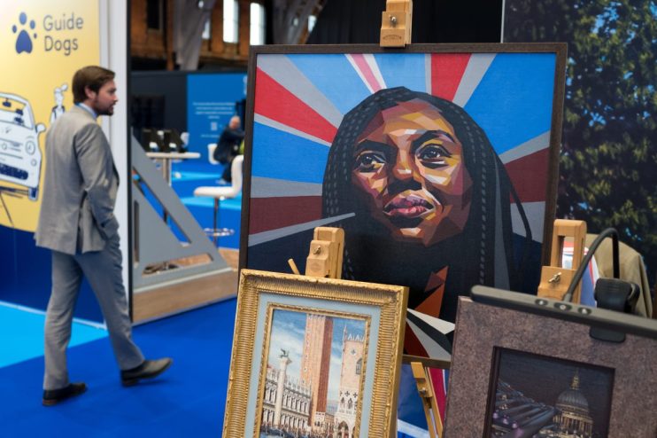 MANCHESTER, ENGLAND - OCTOBER 05: A man walks past a stall selling artwork on the first day of the Conservative party conference on October 05, 2025 in Manchester, England.Kemi Badenoch goes into her first conference as party leader with current polling putting the Conservative Party in fourth place behind Reform, Labour and the Liberal Democrats. (Photo by Ian Forsyth/Getty Images)