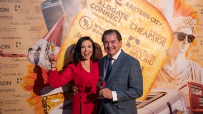 Libby Brodie and Matthew Jukes raising a toast at a celebratory event, smiling and holding a glass, conveying joy and success