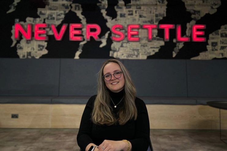 Yana S presenting at a business conference podium, engaging audience with insightful discussion, professional attire