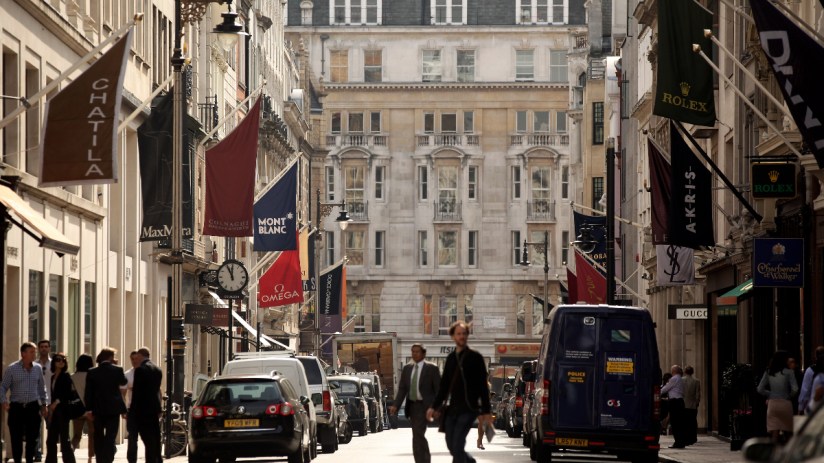 Mayfair street view showcasing luxury shops, bustling activity, and elegant architecture in a prominent business district