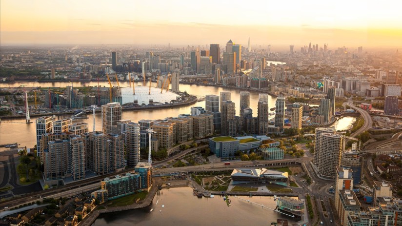 Business meeting with diverse team discussing strategy around a laptop in modern office setting with charts on the wall