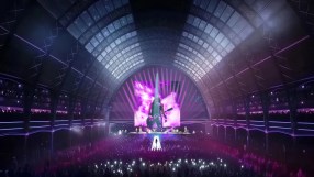 Olympia Grand Concert stage with vibrant lights and audience, featuring a live performance in a large indoor venue