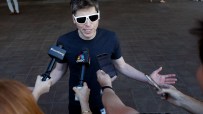 Sam Altman discussing AI advancements at a tech conference podium, wearing a suit, with a large audience in the background.