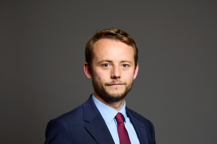 Chris Curtis at House of Commons event, wearing formal attire, engaged in a discussion on current political matters.