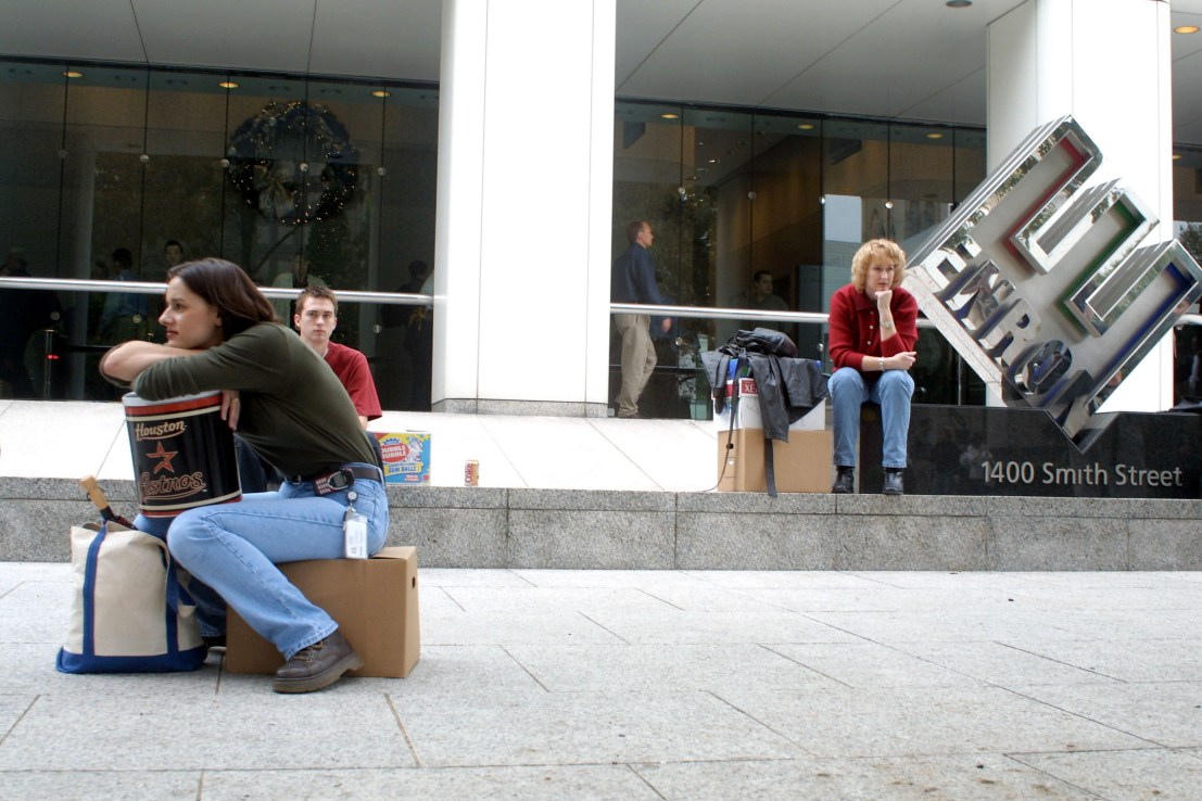 398086 02: Meredith Stewart (L), who worked in Enron's networking/data processing department, sits on her personal belongings in front of the company's headquarters after being laid off December 3,2001 in Houston, Texas. Enron filed for Chapter 11 protection and sued rival Dynegy Inc. for $10 billion as it tries to recover from a tailspin that has crippled the one-time energy giant. The company said an undetermined number of its 21,000 workers, mostly among the 7,500 in Houston, would be laid off. (Photo by James Nielsen/Getty Images)