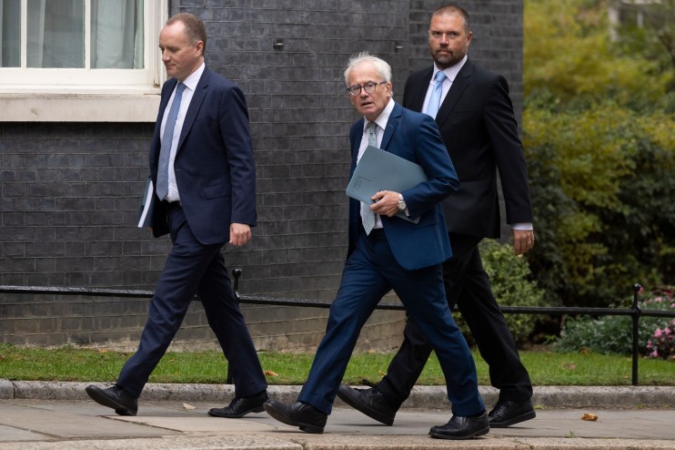 UK Office for Budget Responsibility analysts reviewing economic forecasts and data reports on computer screens in a modern...