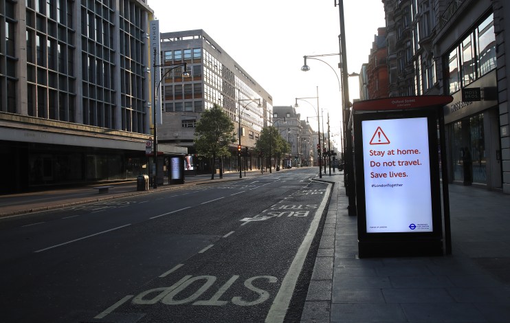 Oxford Street during Covid lockdown with empty sidewalks, closed shops, and minimal pedestrian presence in central London