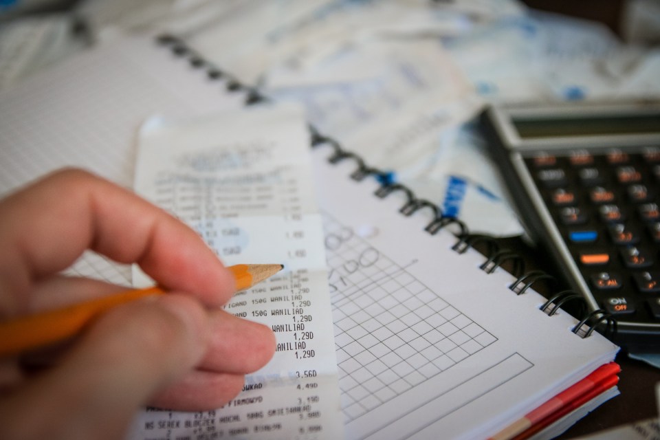 Stacks of currency and financial documents on a desk, representing personal finance and money management concepts.