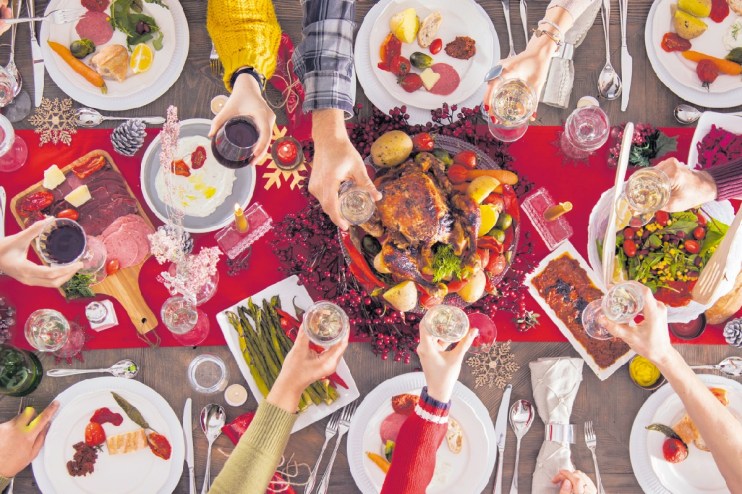 Festive Christmas lunch table with roasted turkey, seasonal vegetables, and holiday decorations, evoking a warm holiday ga...