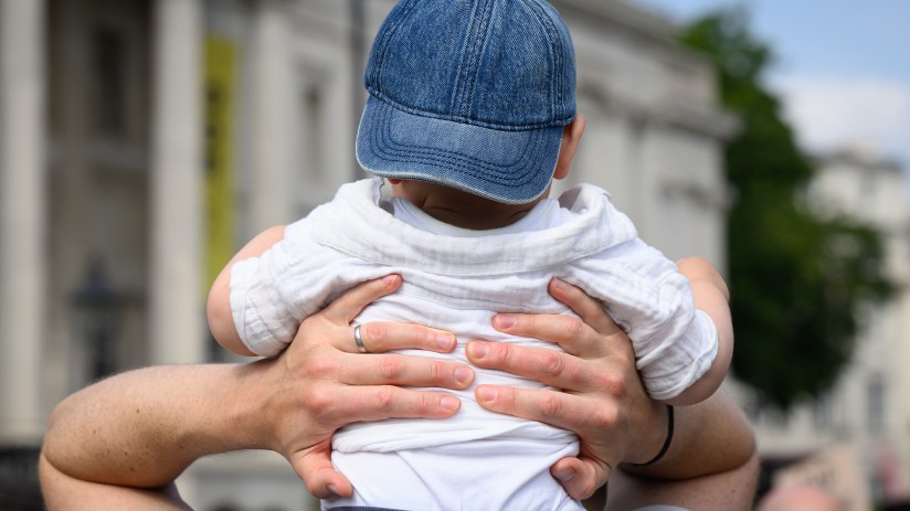 Father cradling newborn baby in a cozy living room, showcasing tender family bond and emotional connection