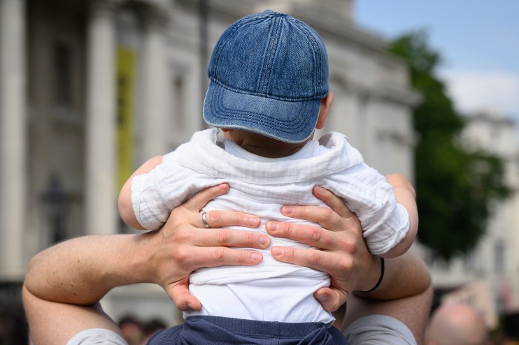 Father cradling newborn baby in a cozy living room, showcasing tender family bond and emotional connection