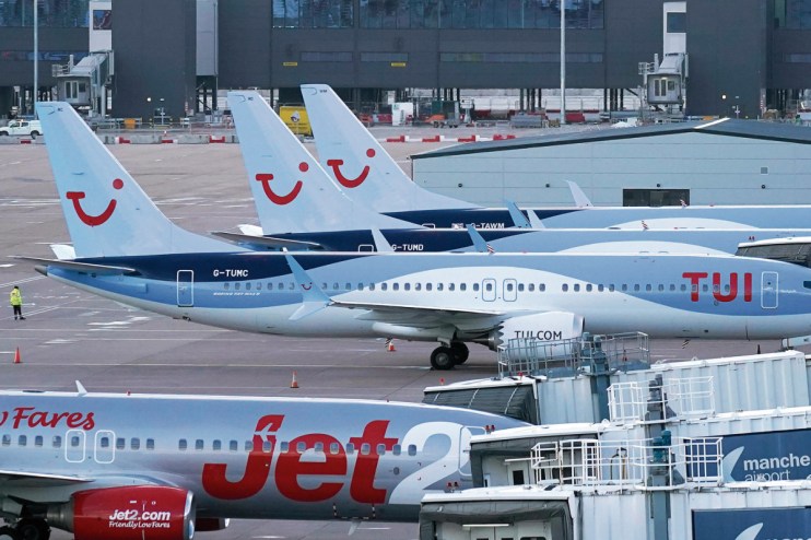 Manchester Airport terminal bustling with travelers, showcasing modern architecture and busy check-in counters