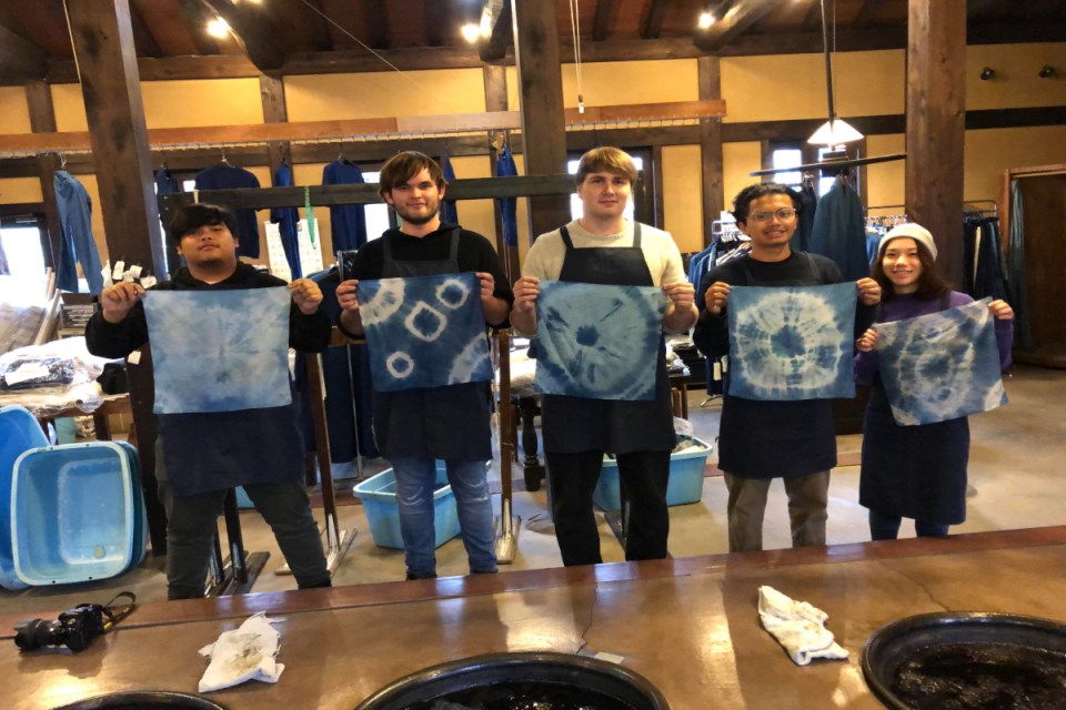 Aizome technology innovation showcased with vibrant blue textile patterns in a modern design laboratory setting.