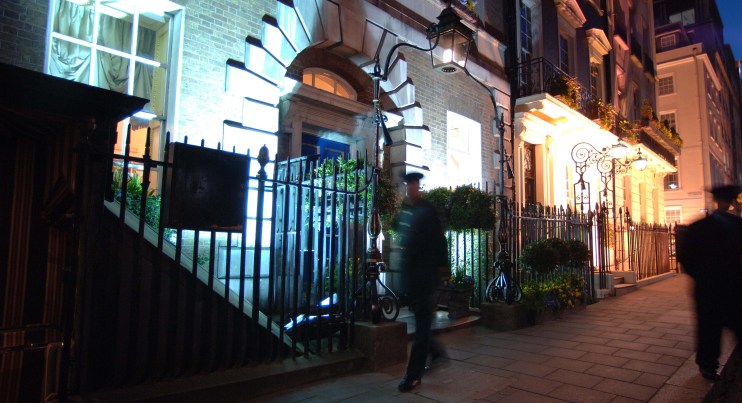 Elegant entrance of Annabels private members club with ornate architecture and vibrant floral decorations in a luxurious s...