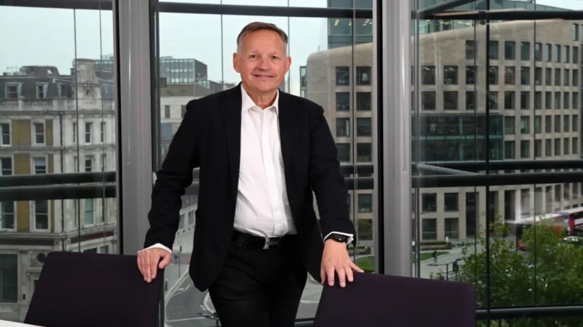 Antony Jenkins speaking at a business conference, wearing a suit, addressing financial industry trends and innovations.