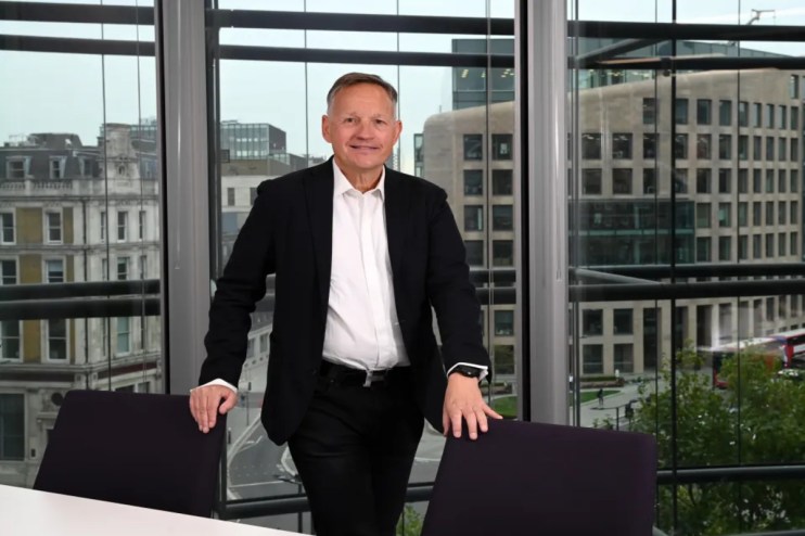 Antony Jenkins speaking at a business conference, wearing a suit, addressing financial industry trends and innovations.