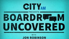 Corporate executives engaged in a strategic meeting around a modern boardroom table, discussing business growth strategies.