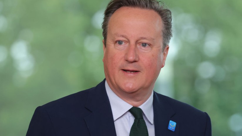David Cameron delivering a speech at a podium, addressing an audience, wearing a suit and tie, in a formal setting