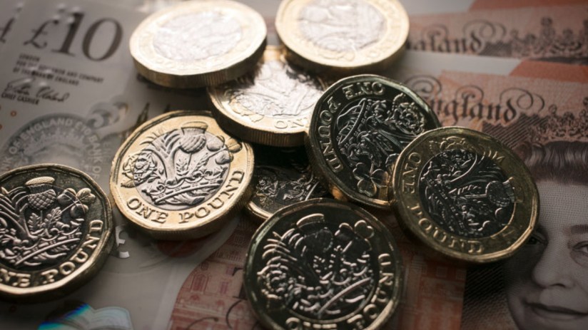 Business professionals engaged in a meeting discussing strategic plans, seated around a conference table with laptops and ...