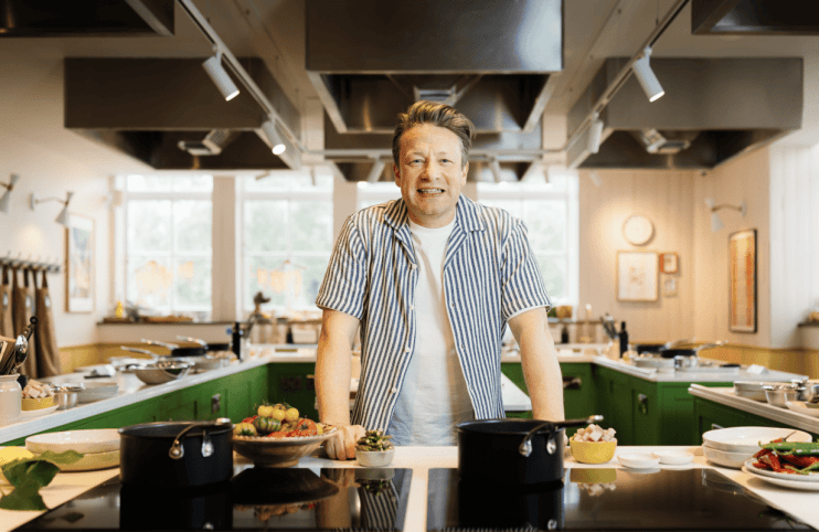 Jamie Oliver showcasing culinary skills in a professional kitchen setting, highlighting his expertise as a renowned chef.