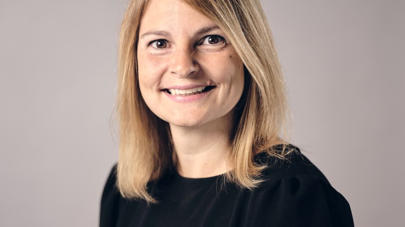 Janine Hirt smiling in professional attire, highlighting her role in business leadership and innovation