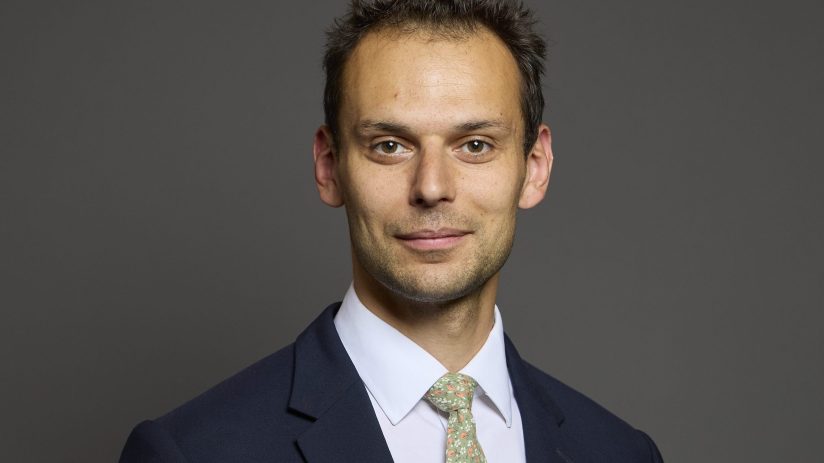 Josh Simons discussing young peoples challenges in the job market at a business conference podium