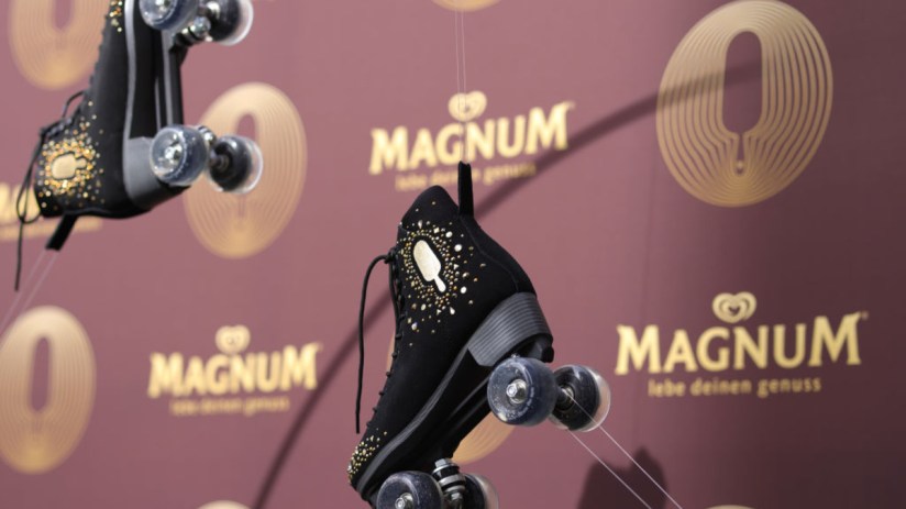 Magnum ice cream bar with rich chocolate coating and creamy vanilla center on a rustic wooden table, perfect for dessert l...