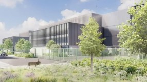 Pinewood Studios construction site showcasing expansion progress with cranes and building materials in a bustling work env...