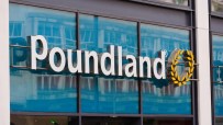 Poundland storefront with shoppers entering and exiting, showcasing the brands logo and discount signage in a bustling str...
