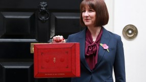 Rachel Reeves speaking at a podium during a business conference, wearing a professional suit, engaging with the audience.