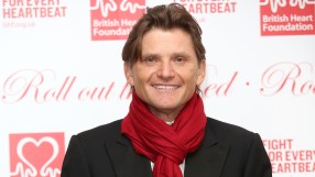 Richard Farleigh speaking at a business conference, wearing a suit, addressing an audience on financial market trends