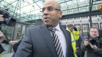 Sanjeev Gupta speaking at a business conference, wearing a suit, addressing sustainability in the steel industry.