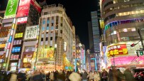 Tokyo cityscape illuminated by vibrant neon lights at night, showcasing bustling urban life and vibrant street scenes.