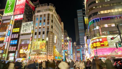 Tokyo cityscape illuminated by vibrant neon lights at night, showcasing bustling urban life and vibrant street scenes.