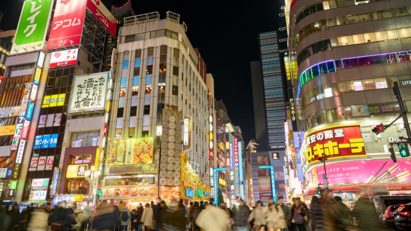 Tokyo cityscape illuminated by vibrant neon lights at night, showcasing bustling urban life and vibrant street scenes.