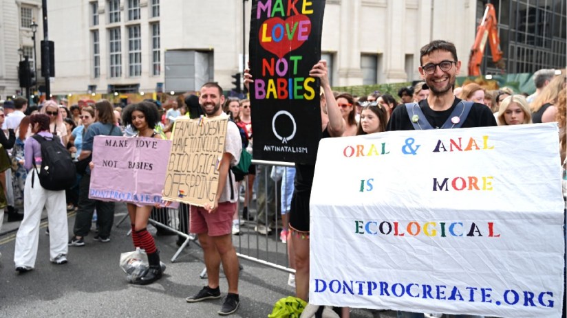 Child-free couple with thoughtful expressions discussing antinatalism concepts in a modern living room setting.