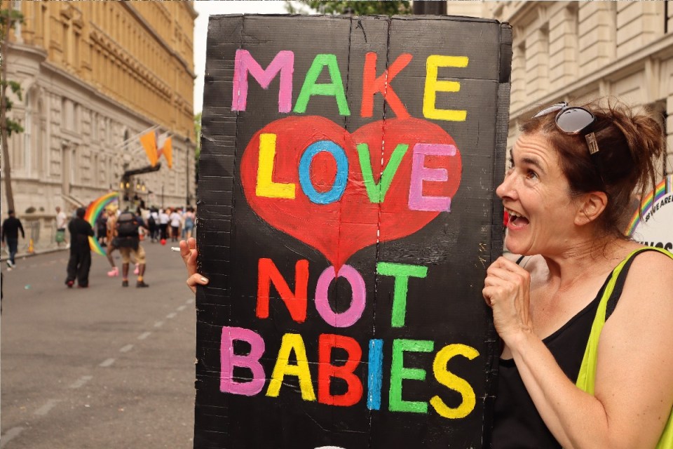 Antinatalist protestors holding signs advocating for population control at a city rally.