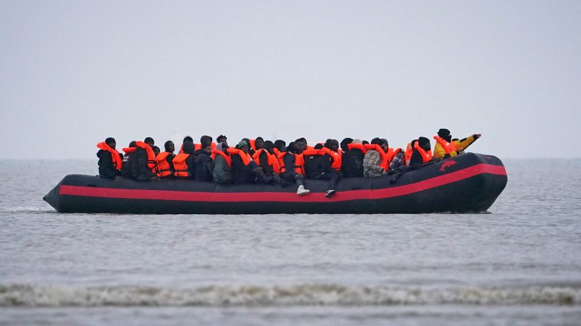 Asylum seekers arriving on a small boat, overseen by Home Office officials, highlighting migration issues in the UK.